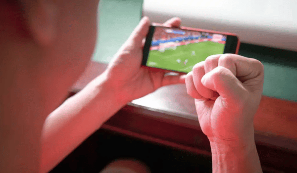 sports fan with fist up celebration while watching sports streaming mobile phone 1024x597.jpg